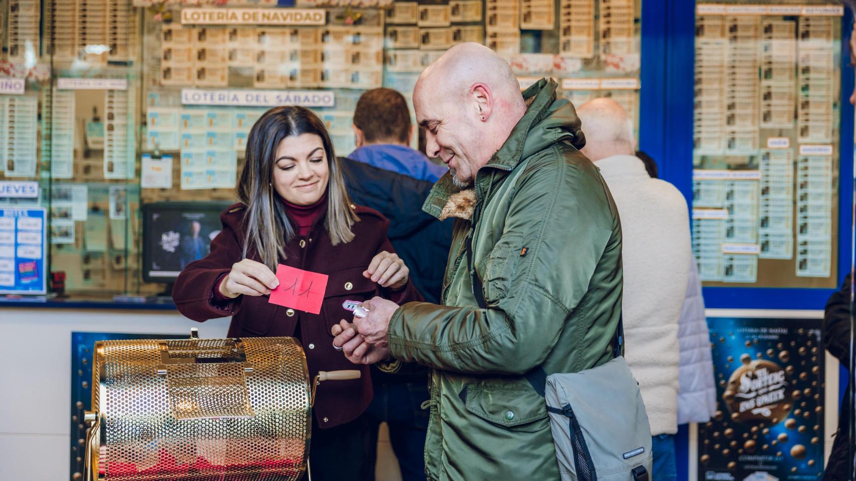 Imagen de Miriam regalando un décimo a un cliente.