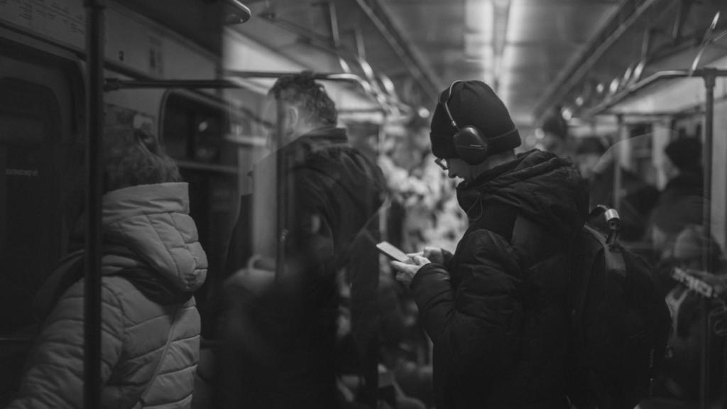Un hombre usando auriculares en el metro