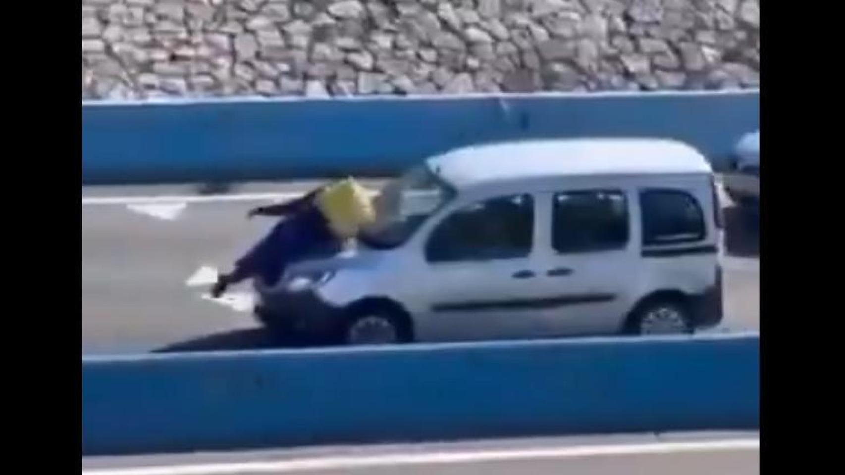 El repartidor, sobre el capó del coche.