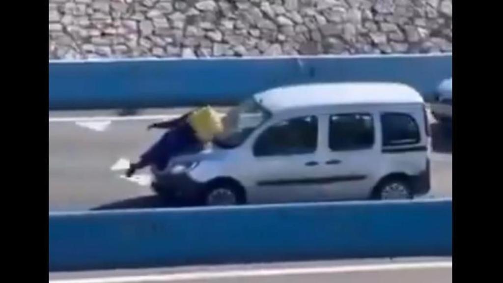 El repartidor, sobre el capó del coche.