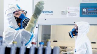 Dos trabajadores en el laboratorio de bioseguridad nivel 3 del IRTA.