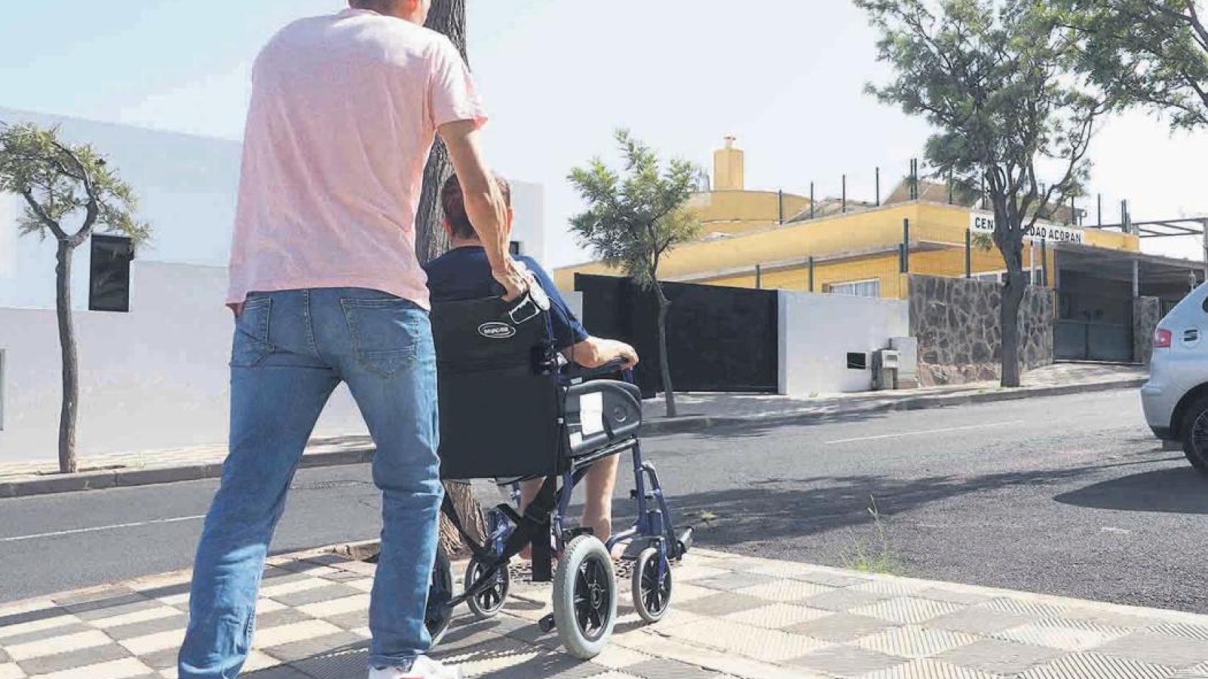 Mujer en silla de ruedas acompañada de un voluntario.