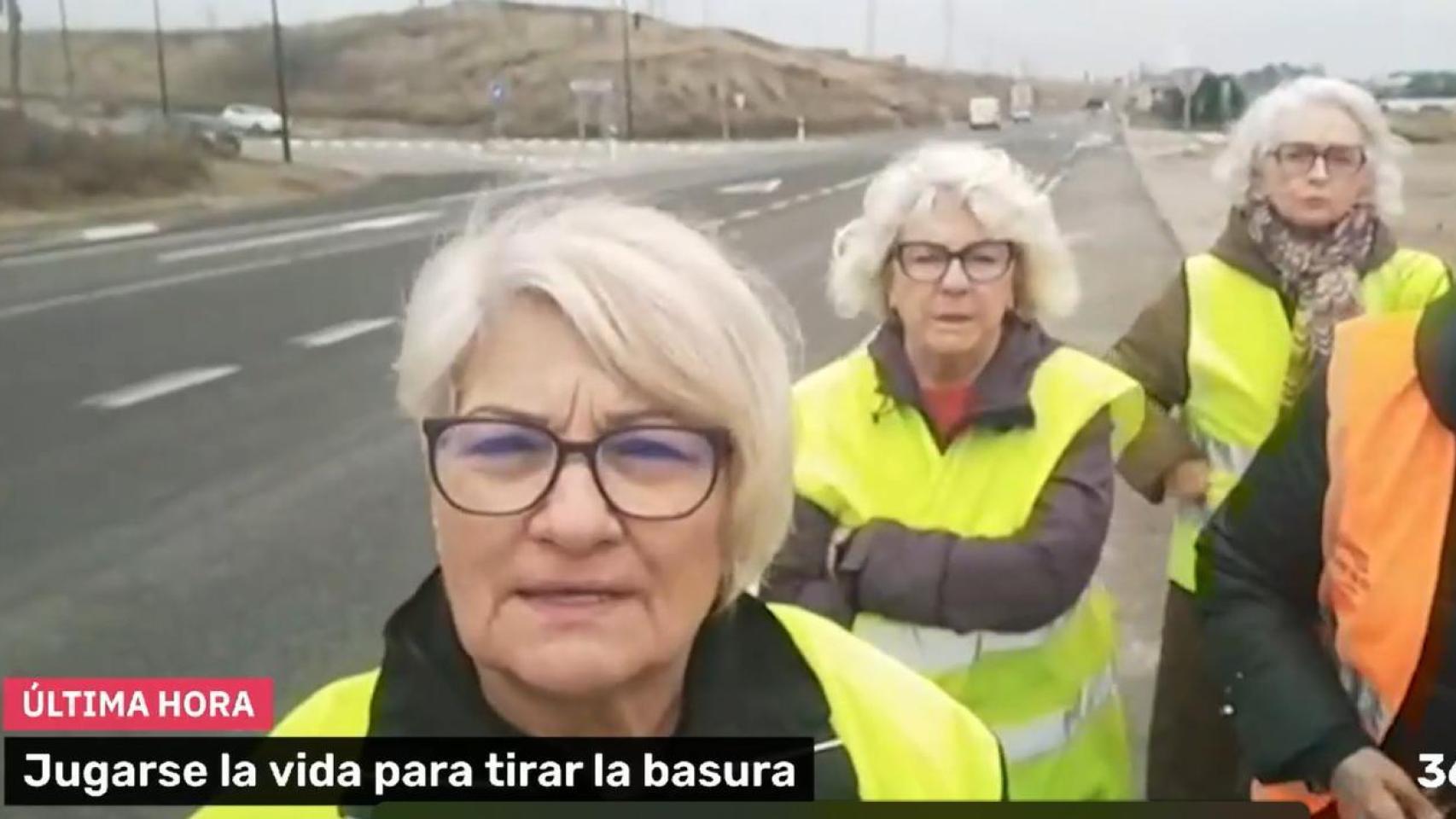 Vecinos de Movera, Zaragoza, caminan por el arcén de la carretera nacional N-II para tirar la basura
