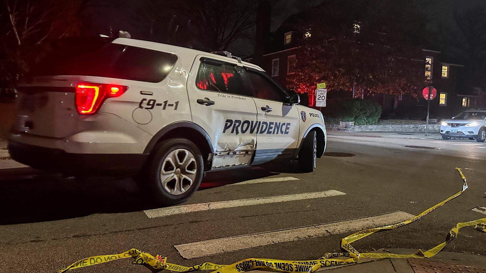 Un coche de policía pasa junto a una cinta policial tendida en la calle tras un tiroteo en la Universidad de Brown, en Providence.