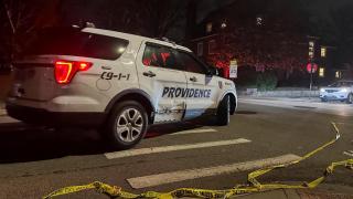 Un coche de policía pasa junto a una cinta policial tendida en la calle tras un tiroteo en la Universidad de Brown, en Providence.
