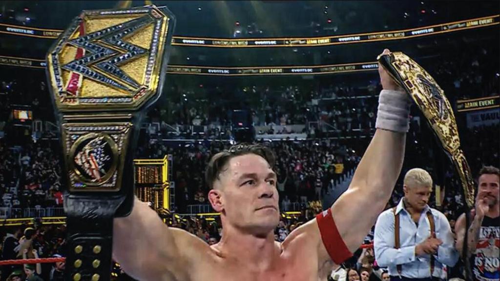 John Cena levanta los títulos mundiales de la WWE durante su despedida en el ring