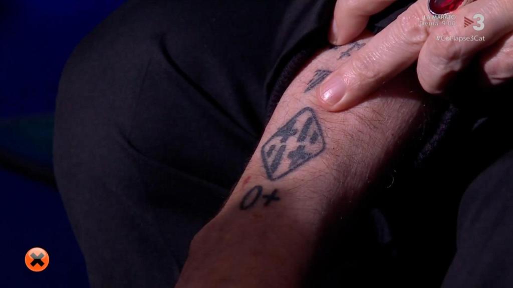 Loquillo mostrando su tatuaje con el escudo de la ciudad de Barcelona.
