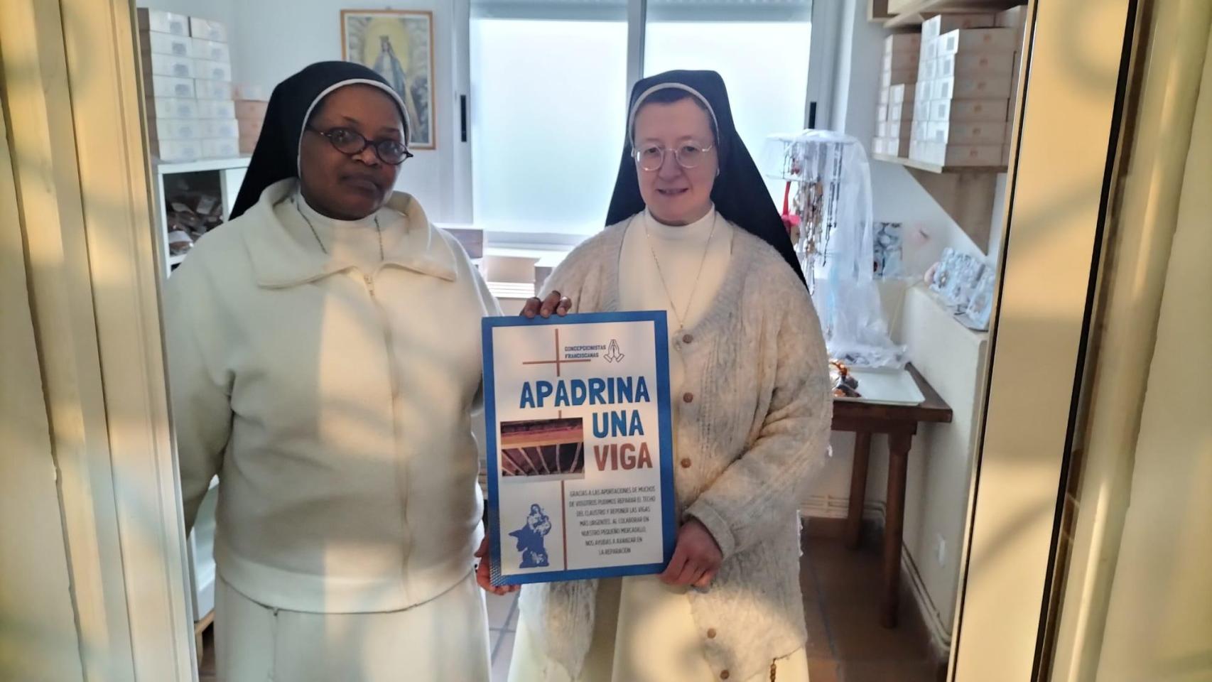 La Madre Nuria, abadesa, posa con el cartel de la campaña junto a una hermana