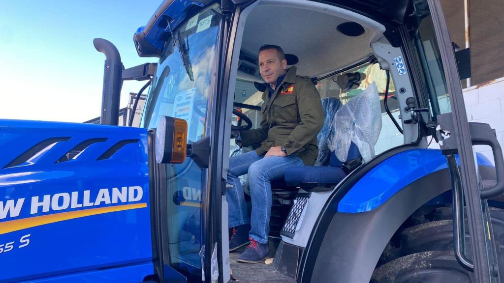 Óscar Fernández montado en un tractor durante un acto de campaña.