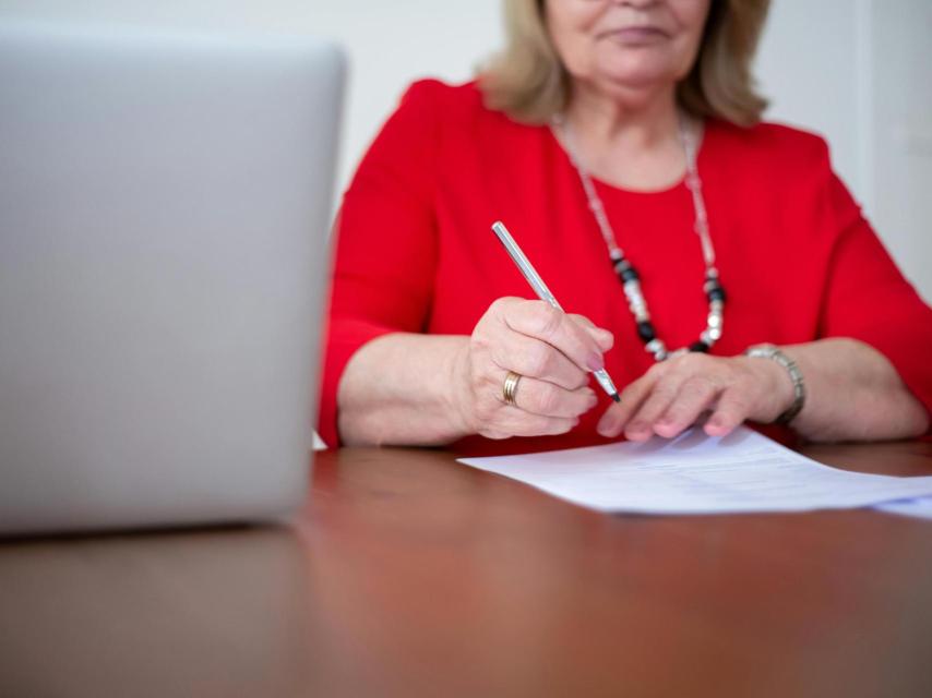 Una mujer firmando papeles en el abogado.