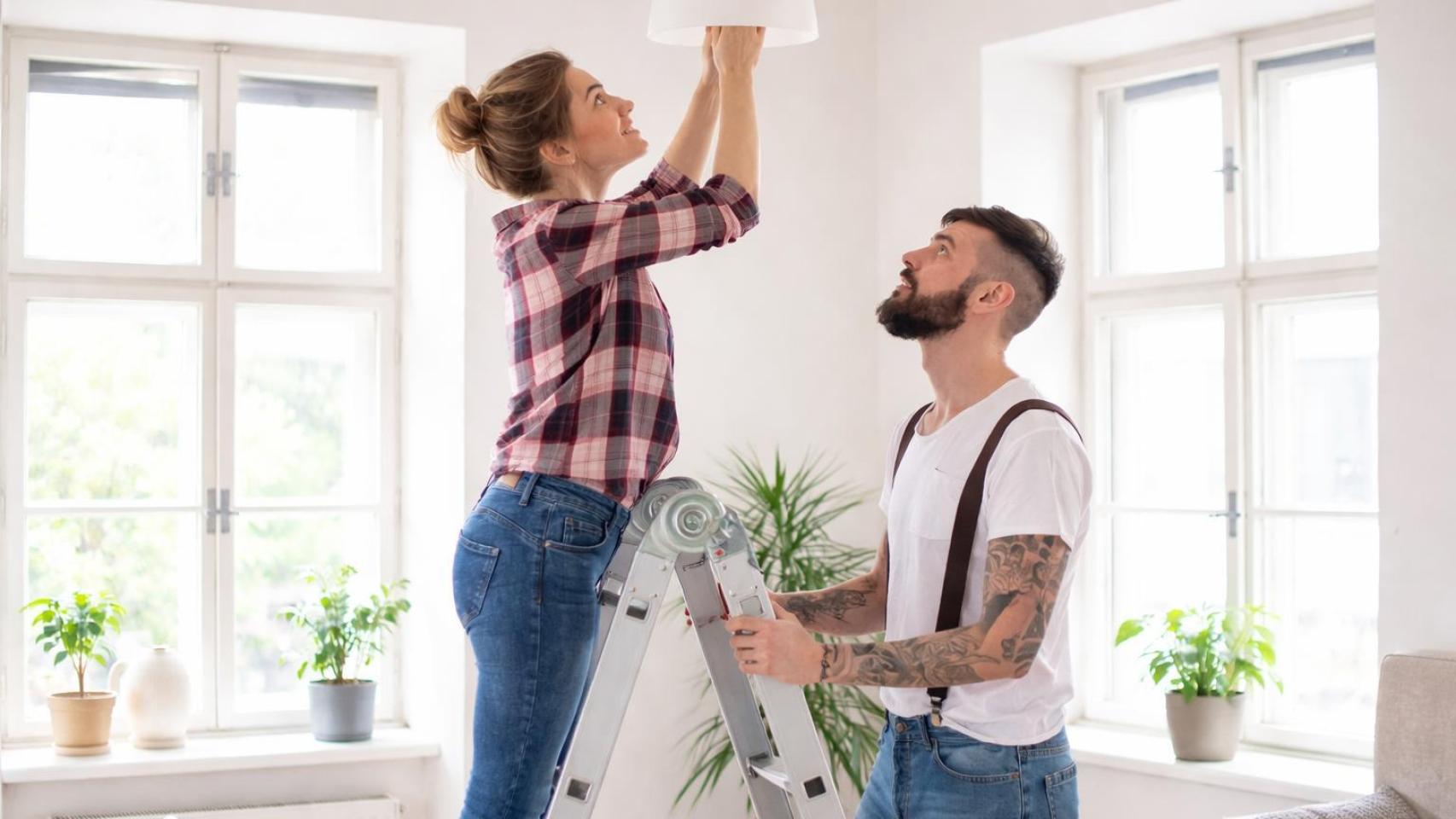 Una pareja joven colocando una bombilla.