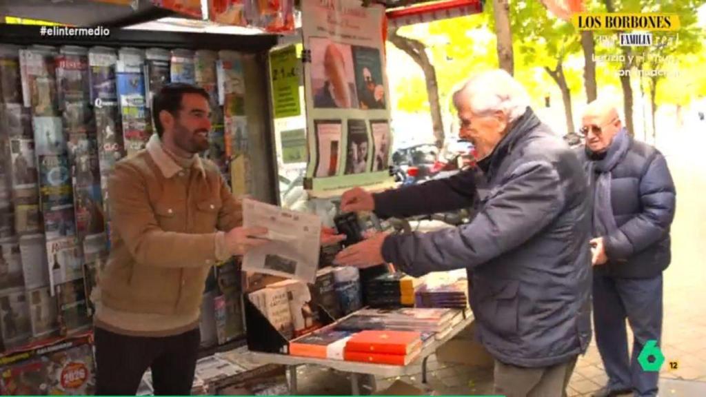Miguel Sanz vendiendo un periódico a uno de sus clientes habituales.