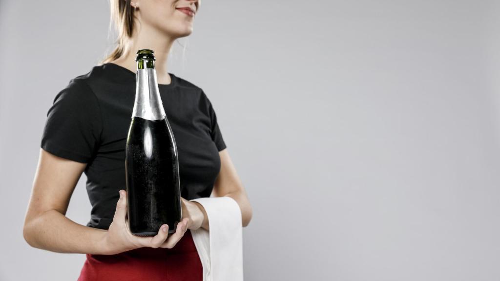 Camarera sirviendo vino en botella mágnum.