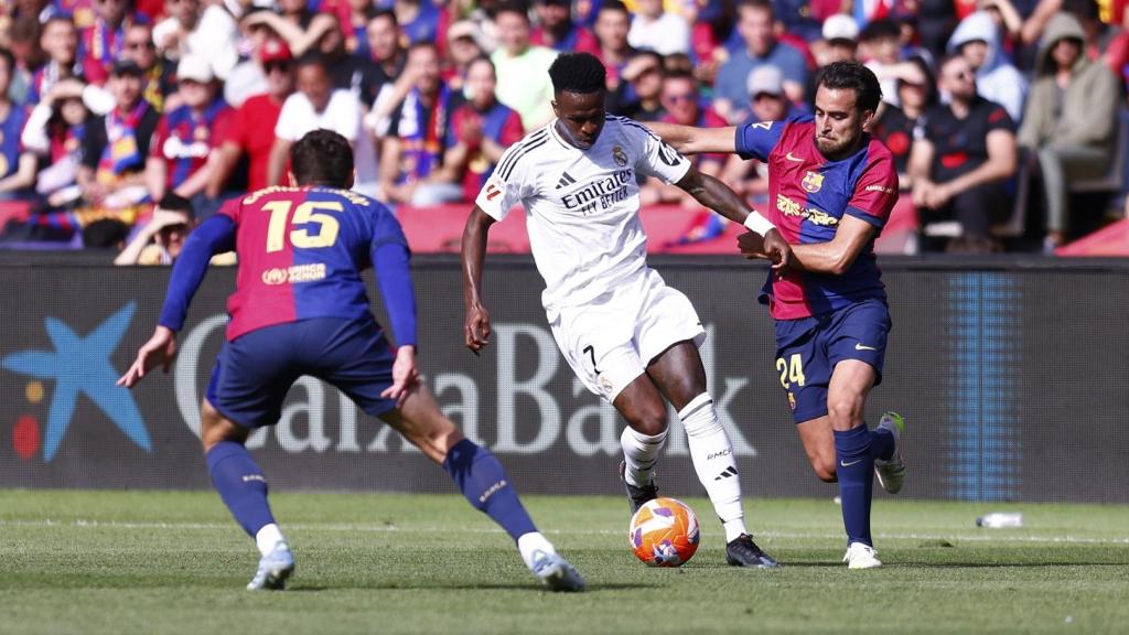 Vinicius conduce el balón presionado por Eric García y Christensen.