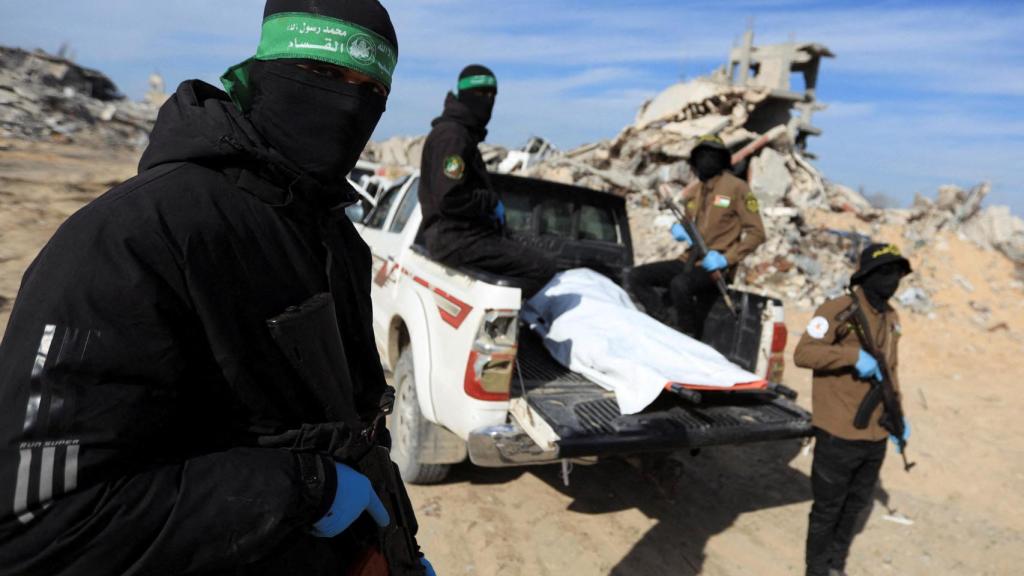 Militantes palestinos de Hamás y de la Yihad Islámica recuperan el cuerpo de un rehén israelí.