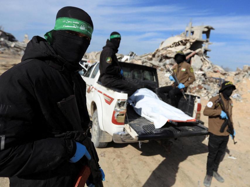 Militantes palestinos de Hamás y de la Yihad Islámica con el cuerpo de un rehén israelí.
