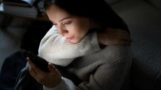 Imagen de archivo de una mujer mirando su teléfono.