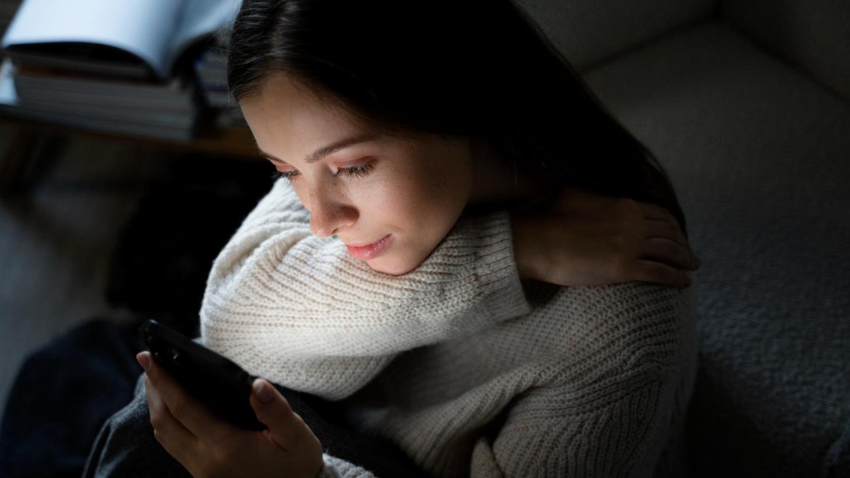 Imagen de archivo de una mujer mirando su teléfono.