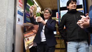 Varias personas celebran en una administración de lotería.