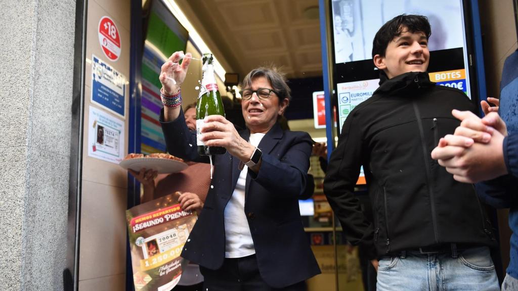 Varias personas celebran en una administración de lotería.