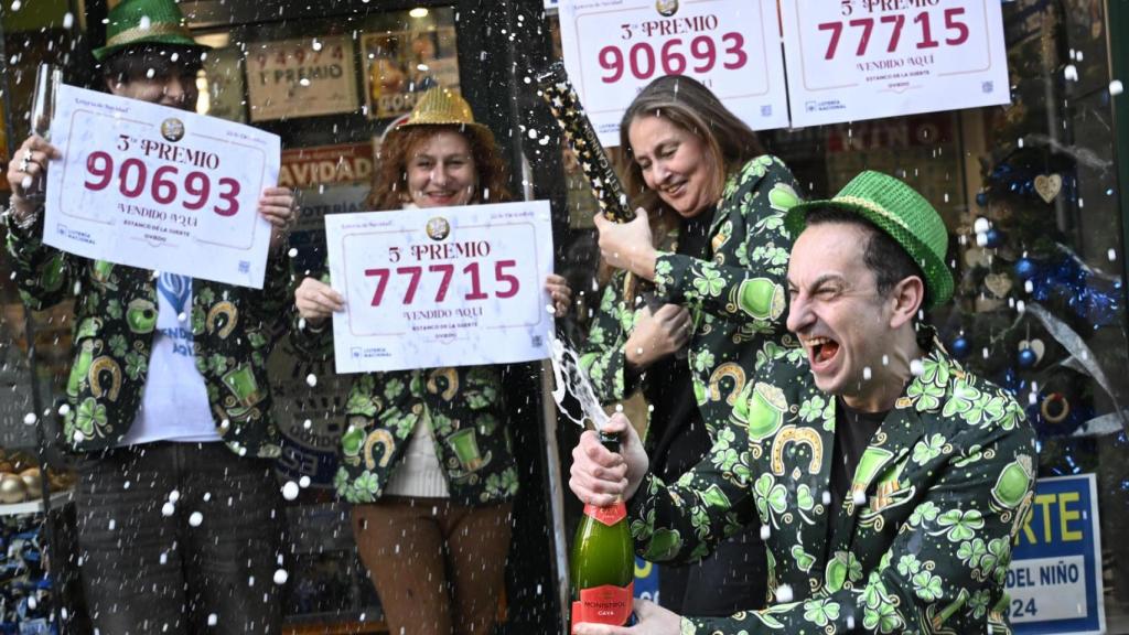 Empleados de una administración de lotería de Oviedo celebran tras haber vendido décimos del 90693, el tercer premio, y del 77715, uno de los quintos premios.