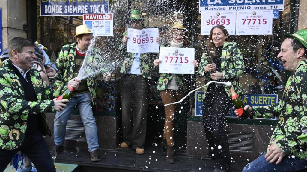 Empleados de una administración de Lotería de Oviedo donde han vendido décimos del tercer y quinto premio de la Lotería de Navidad.