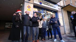Imagen de trabajadores de una administración de loterías que celebrando el premio.