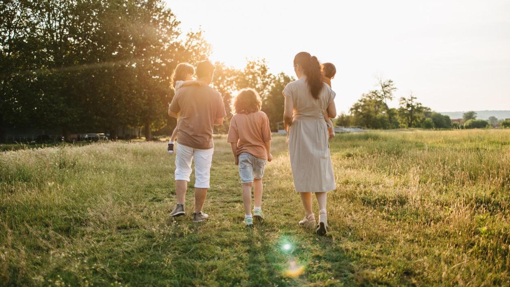 Una familia con hijos caminando por el campo.