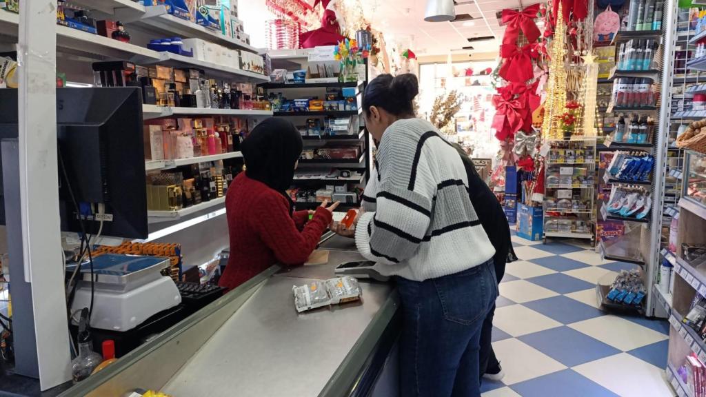 Sabah e Salma (de costas) atendem um cliente no supermercado Express de Talayuel.