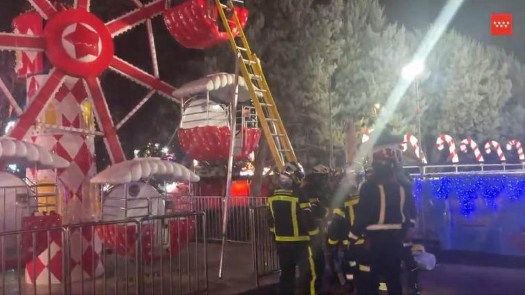 Momento en el que los bomberos rescatan a los cuatro menores y a una mujer en una noria de Móstoles.