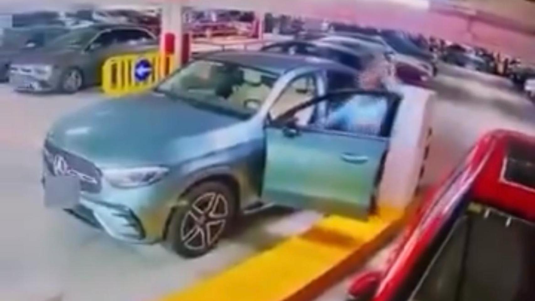 Una mujer destroza la valla de un garaje