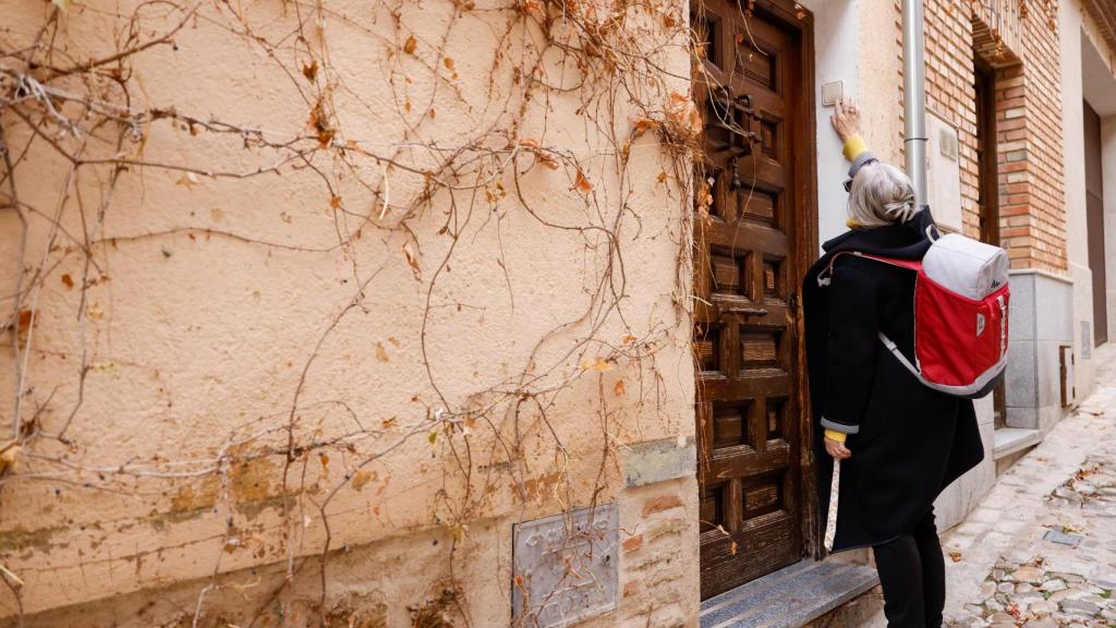 Una voluntaria de la red llama al timbre de un domicilio del Casco Histórico de Toledo tras un recorrido a pie de apenas unos minutos.