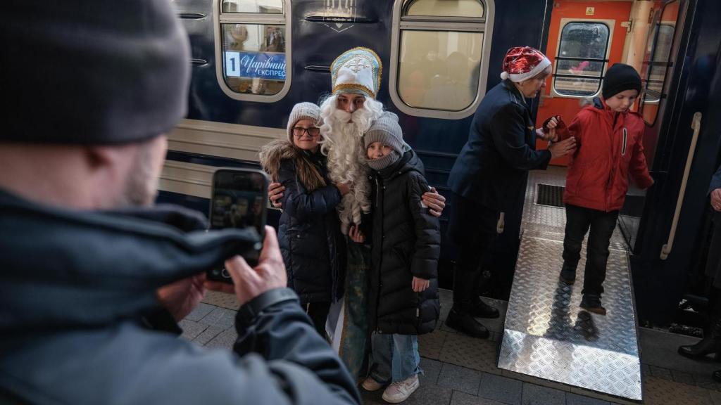 Niños ucranianos se hacen fotos con San Nicolás el pasado 6 de diciembre, en Kiev, durante una actividad en tren para celebrar esta tradición.