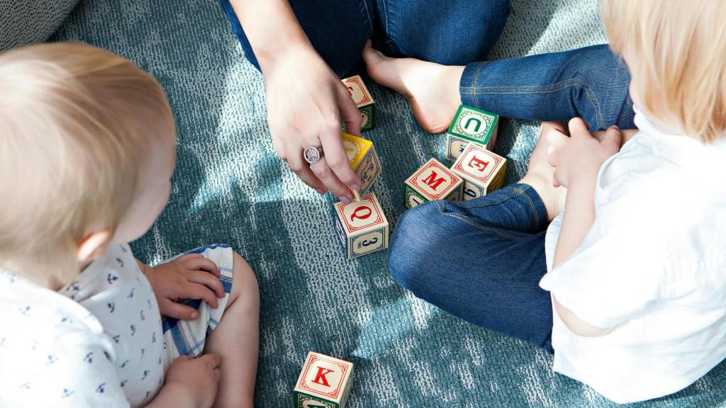 Imagen de archivo de una madre jugando con sus hijos.