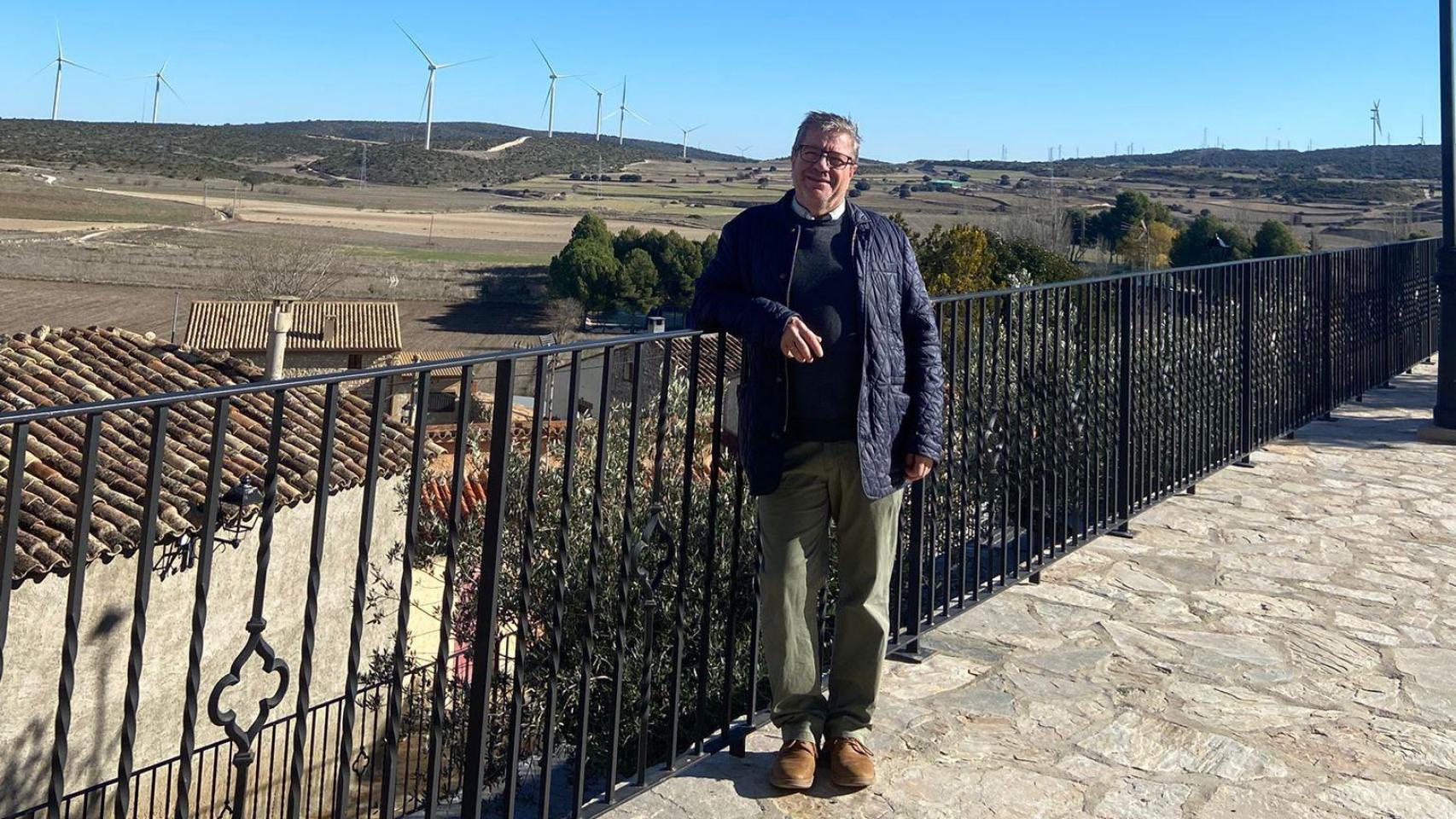 El alcalde de Fuendetodos, Enrique Salueña Mateo, frente a unos molinos de viento