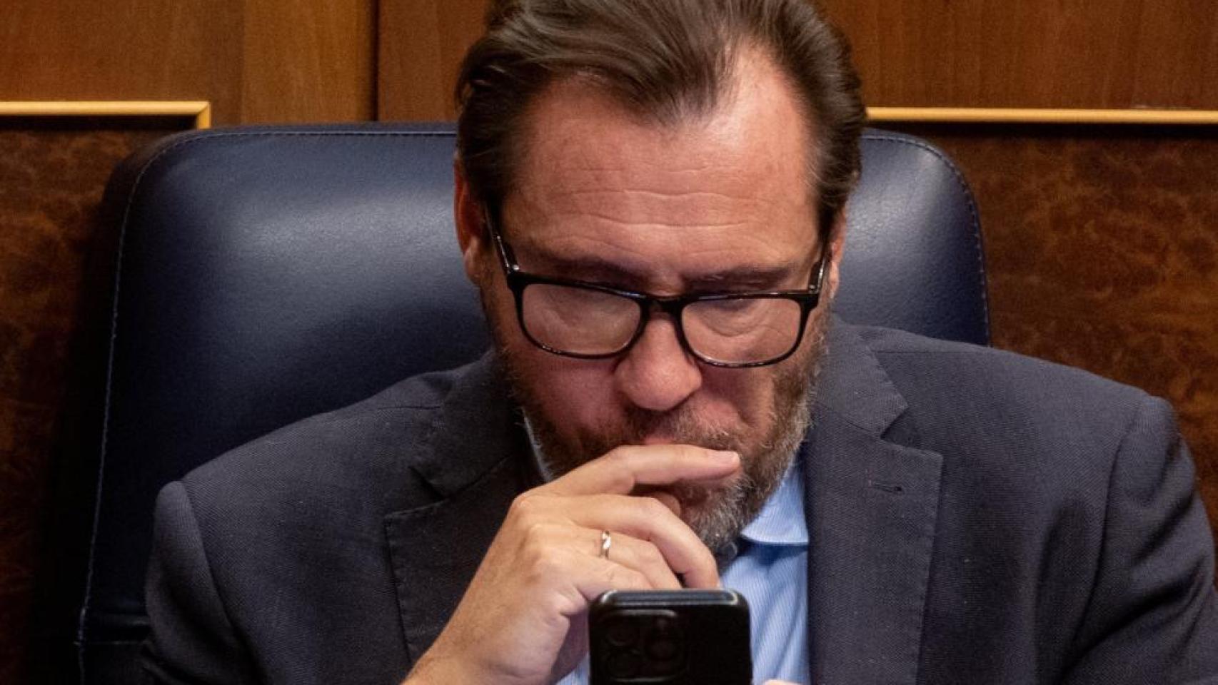 Óscar Puente, consulta su teléfono en el Congreso de los Diputados.