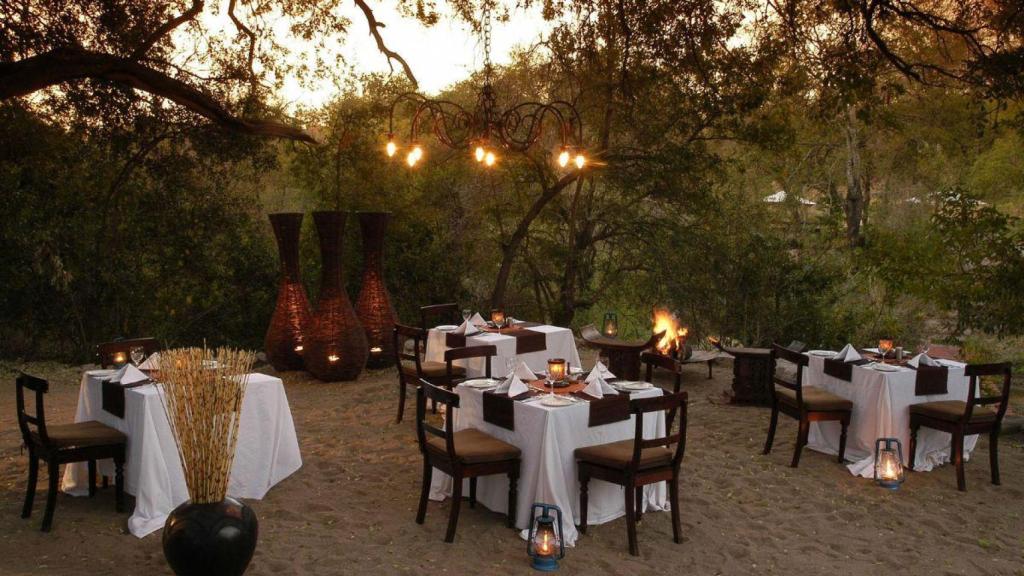 Cena en plena naturaleza y con la puesta de sol al fondo en Sabi Sabi.