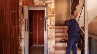 Un vecino de Paiporta barre las escaleras del portal de su edificio afectado por la dana.