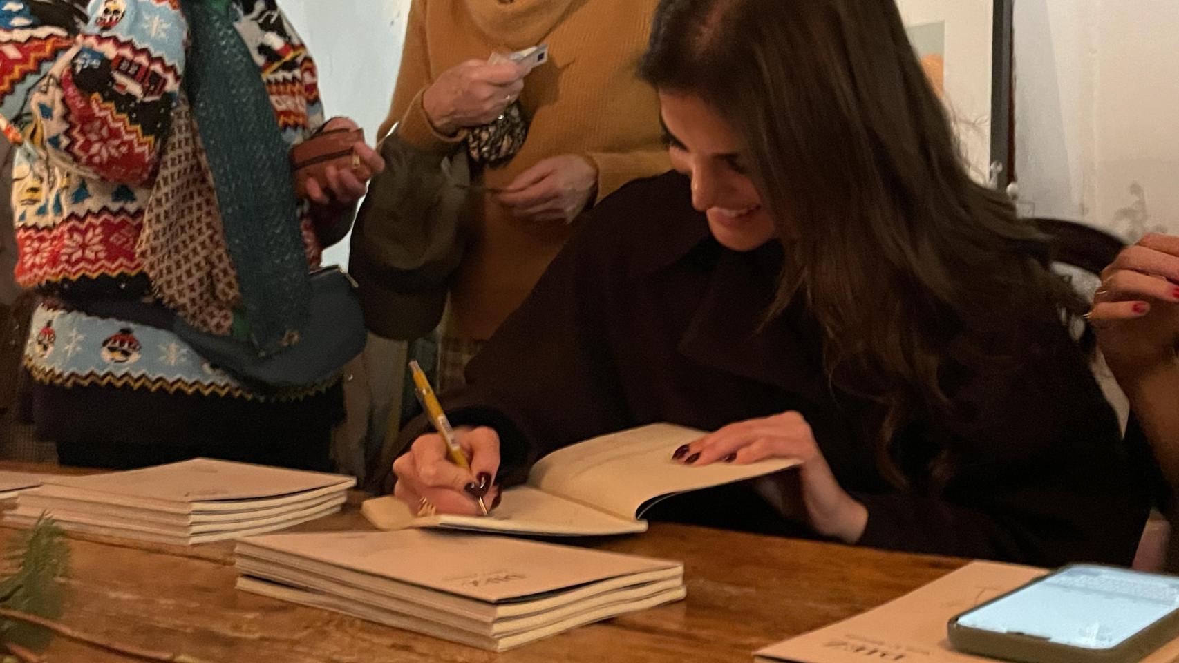 Sara V. Alemán firmando uno de los ejemplares.