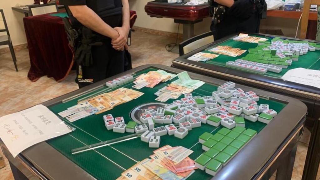 Dos agentes de la Unidad Adscrita de la Policía Nacional en el casino ilegal intervenido.