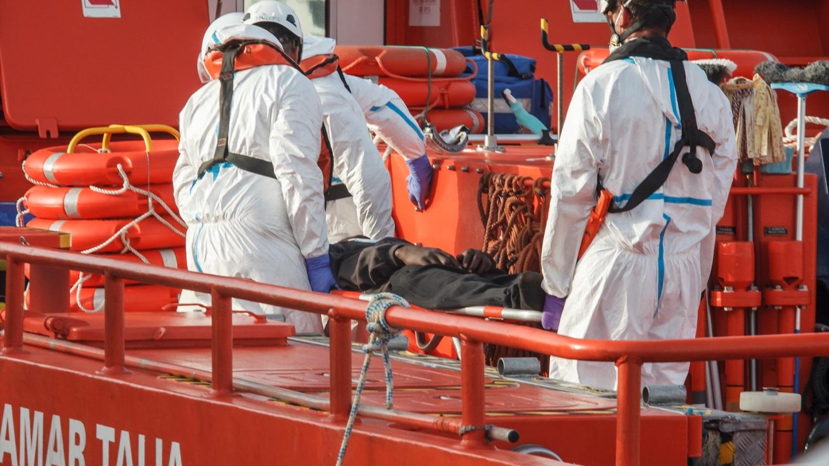 Equipos de rescate médico ayudan a inmigrante que ha llegado en cayuco hasta Arguineguín, en Gran Canaria.