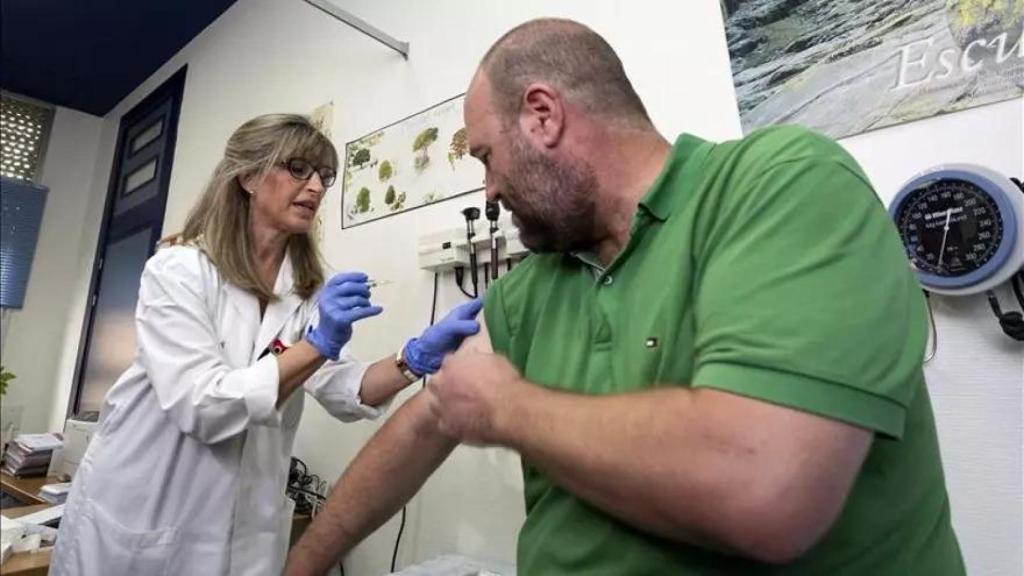 un hombre de mediana edad se vacuna en una consulta de primaria.