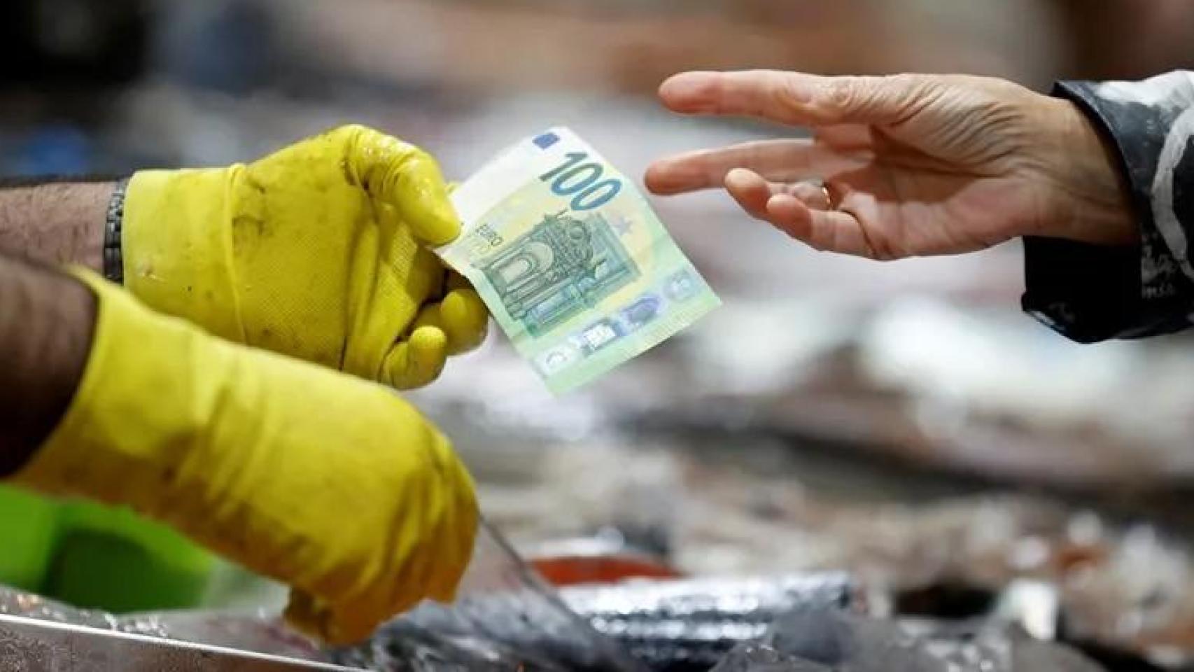 Una persona paga pescado en el mercado de la plaza de Lugo.