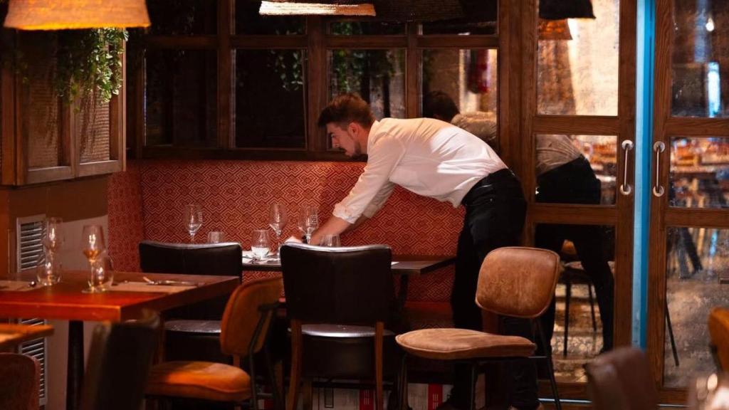 Un camarero recogiendo una mesa.