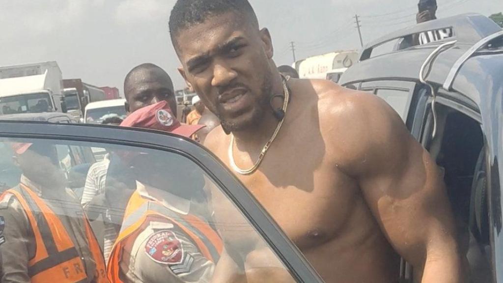 El boxeador británico Anthony Joshua se sube a un vehículo de emergencia tras sufrir un accidente automovilístico en Nigeria