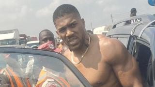 El boxeador británico Anthony Joshua sube a un vehículo de emergencia tras un accidente automovilístico en Nigeria