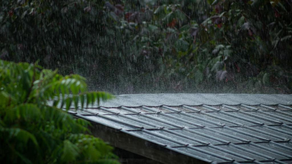 Lluvia cayendo en un tejado de una casa.