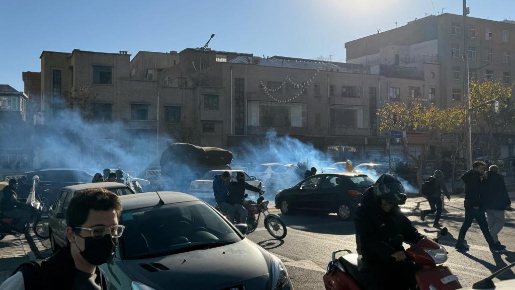 Comerciantes iraníes protestan por la situación económica, mientras la policía antidisturbios lanza gases lacrimógenos en Teherán.