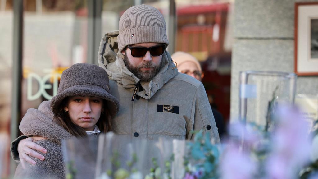 Dos personas guardan luto por los muertos.