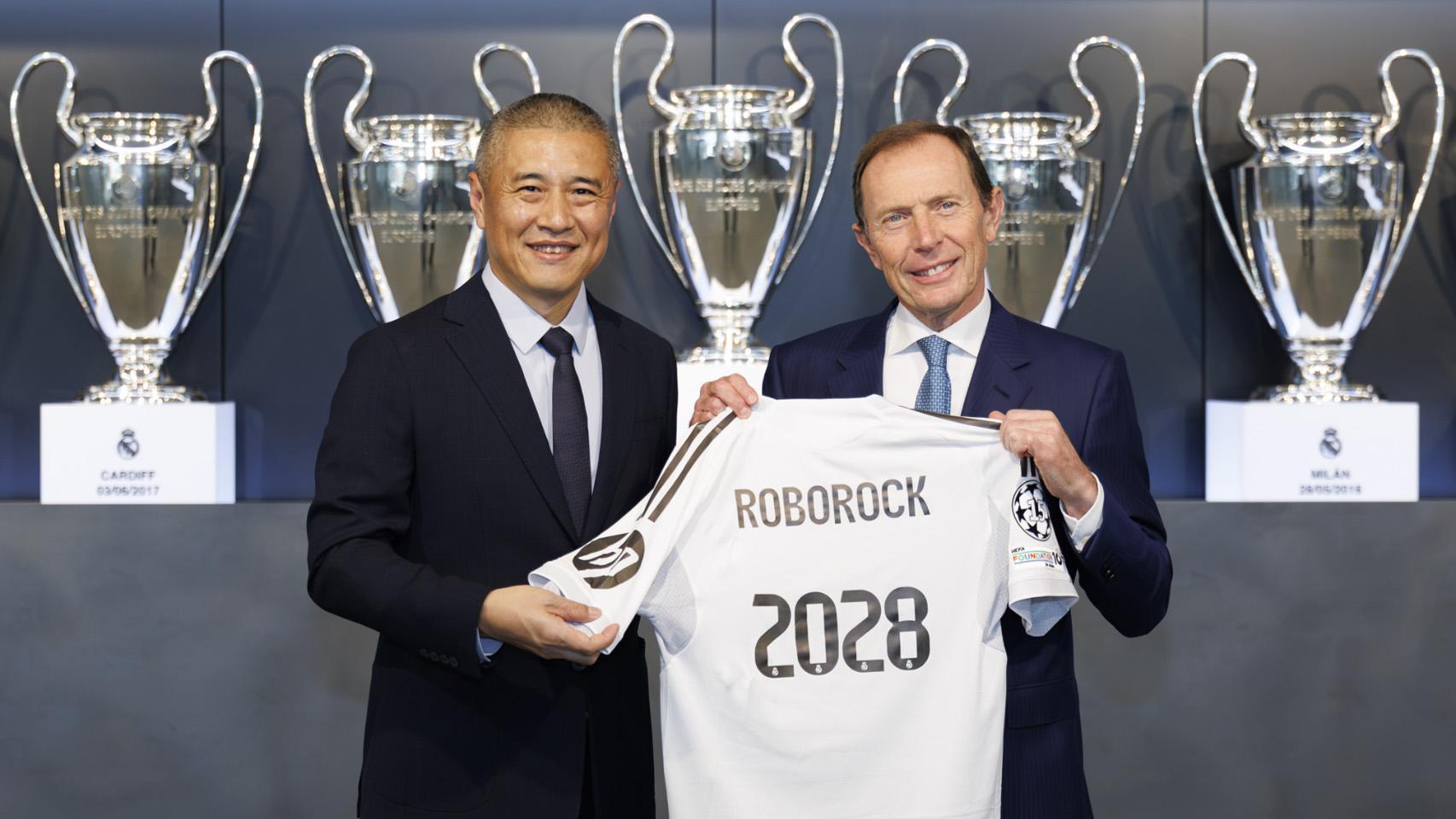 Quan Gang, presidente de Roborock (izqu.) firma el acuerdo con Emilio Butragueño, director de Relaciones Institucionales del Real Madrid (der.).